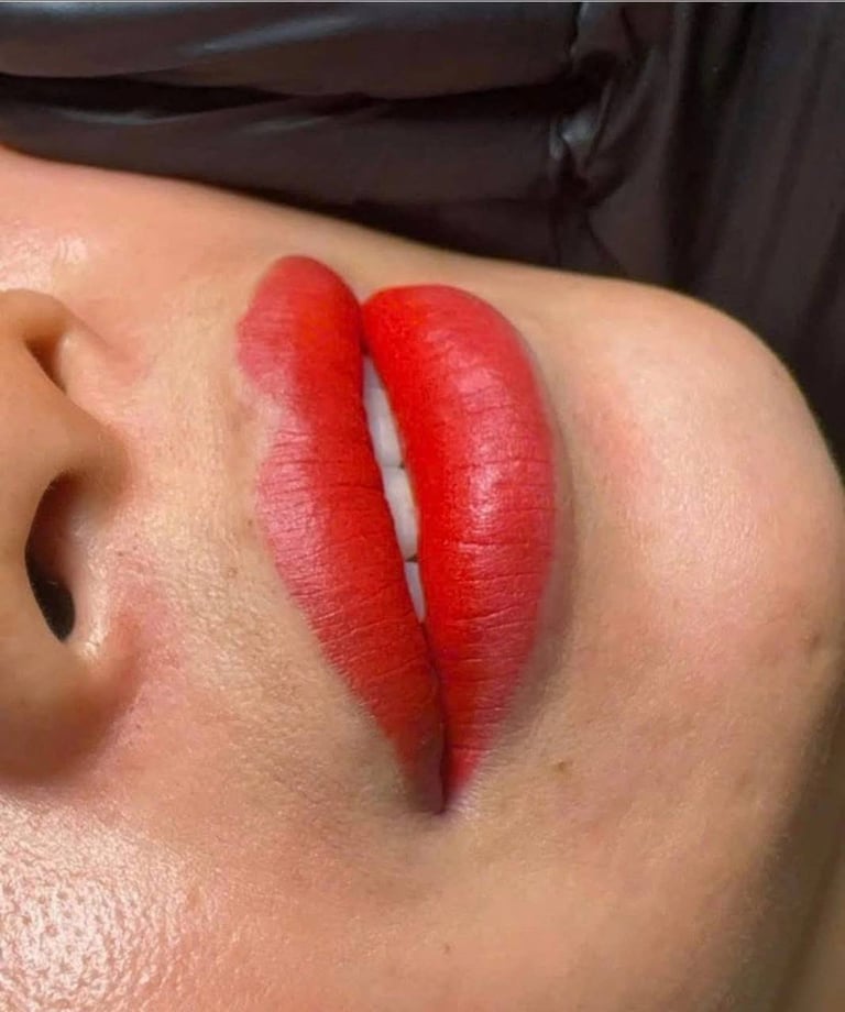 Close-up of persons face with bright red lipstick applied to lips, showing vibrant color against skin tone